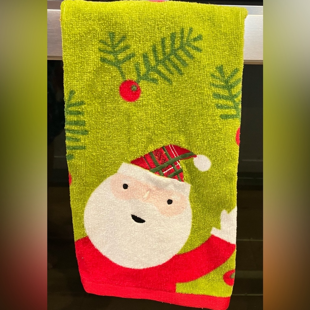 Christmas hand towel a smiling Santa Claus with a pine needle pattern.
